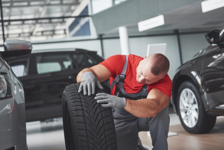 Mechanic holding tire tire repair garage replacement winter summer tires